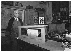 Elbridge Churchill Jacobs beside a large seismograph instrument 
