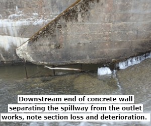Downstream end of concrete wall separating the spillway from the outlet works, note section loss and deterioration. 