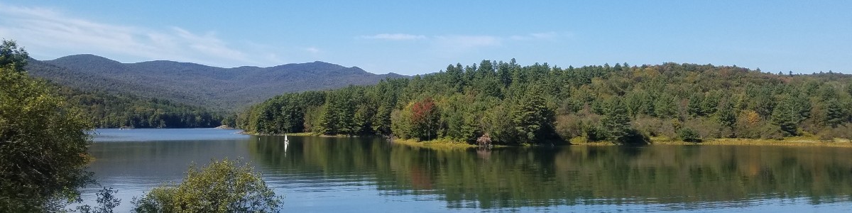 blue-green mountains over a reflective water body in summer