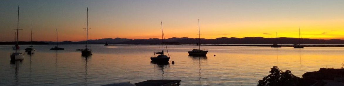 sunset over a lake with boats on the water