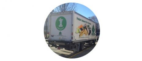 A box truck with the food scrap symbol on it--a white apple core within a green circle