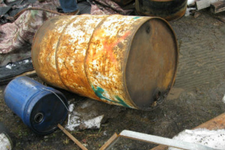 Picture of an overturned drum containing hazardous waste with waste spilled onto the ground