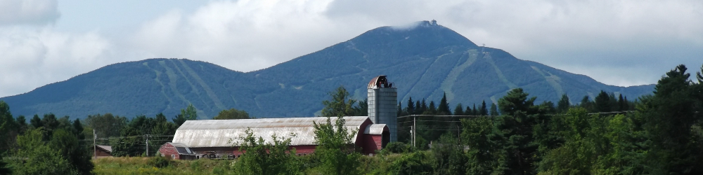Farm on hill with ski area mountain in background