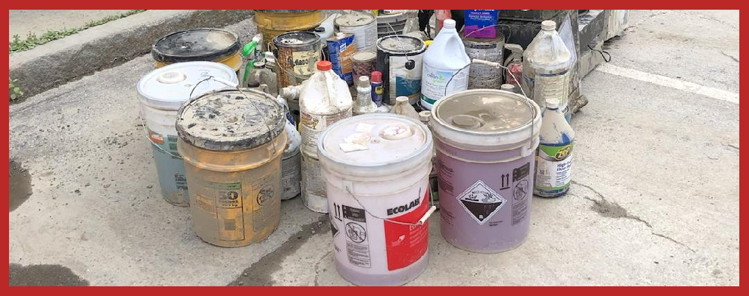 Containers of flood related hazardous wastes temporarily stored in a parking lot