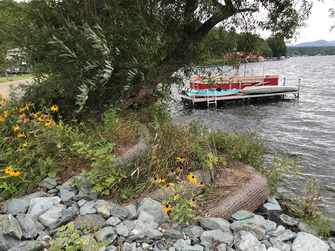 rocky lake shore with pontoon boat and rocks