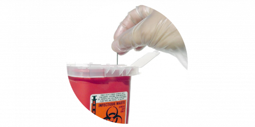 a latex-gloved hand placing a used syringe into a biohazard container
