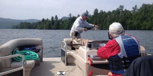 Two people taking water samples from the lake