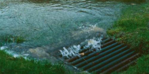 Flooded waters rushing into storm drain