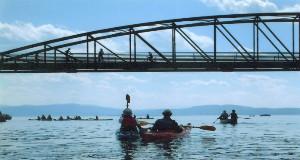 Paddlers paddling under the Winooski Bike Bridge
