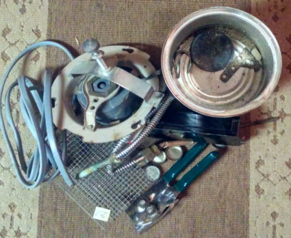 Medium and small pieces of scrap metal, including an old tool, part of a machine, wire-mesh, bottle caps, and springs.