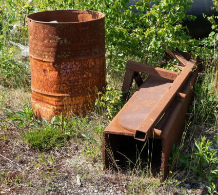 A rusty metal drum and a large piece of metal machinery.