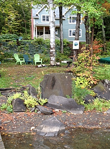 Shoreline edge of property with house in background