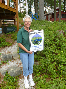 Woman holding a Lake Wise Award sign