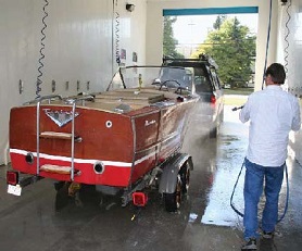 Car and trailered boat being washed in self-service car wash