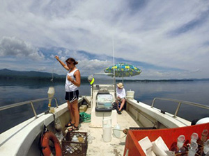 Woman on boat pulling water sample from Lake Champlain