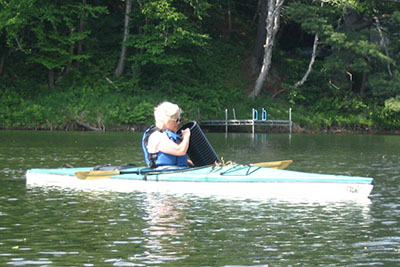 woman inspecting invasive collector from her kayak