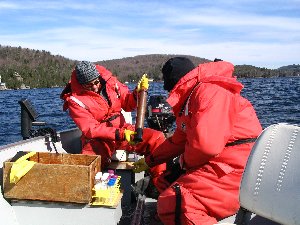 Two people out in a boat working with monitoring equipment