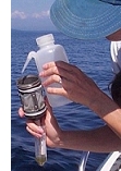 Collecting water samples from a boat.