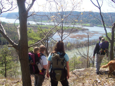 Hikers overlooking the lake from an elevated, wooded vantage point