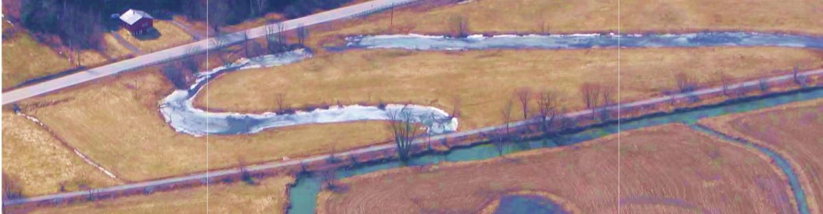 Aerial view of river, surrounding farm fields, and adjacent roadways