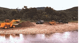Heavy equipment removing river gravel