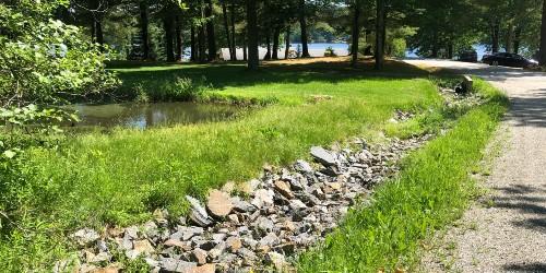 Rock lined swale along road near lake 