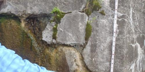 hand holding a ruler against concrete