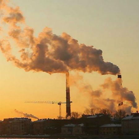 Stacks emitting pollution at sunset